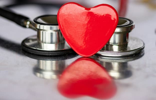 Coração vermelho em frente a um estetoscópio, representando a saúde cardiovascular e o uso de medicamentos cardíacos.