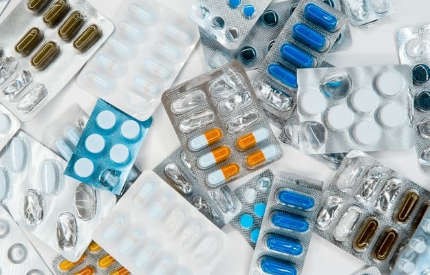 Cartelas com comprimidos e cápsulas de diferentes remédios para organização de uma lista de medicamentos para controle e acompanhamento do tratamento.