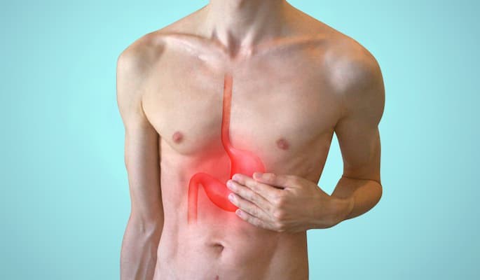 Pessoa com a mão sobre o abdômen, com sintomas de desconforto gastrointestinal e refluxo tratados com domperidona.